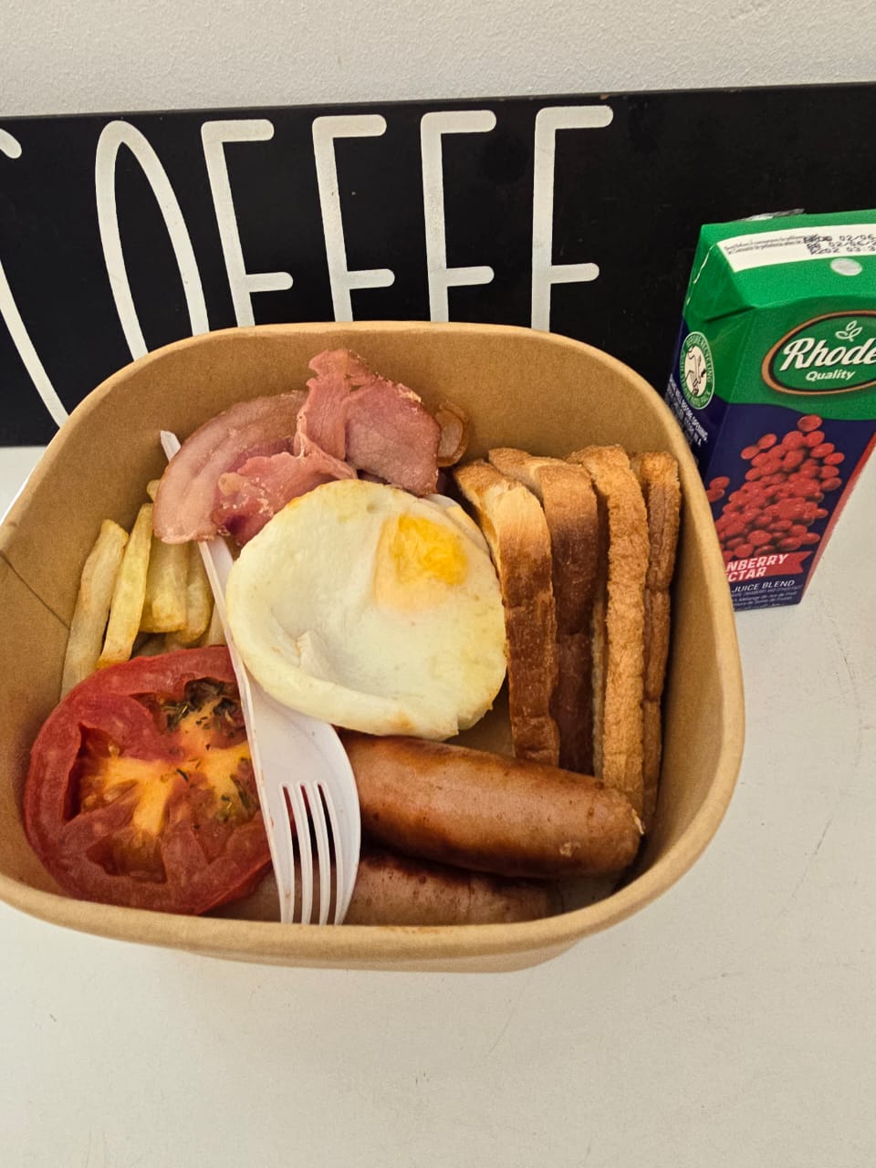 Full breakfast box with bacon, egg, tomato, sausages and toast